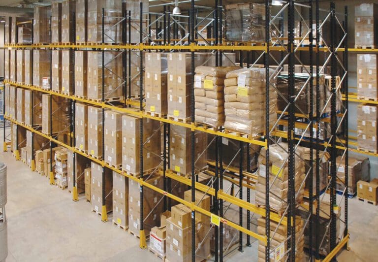 Heavy-duty pallet racking system loaded with boxed goods in a warehouse, featuring yellow beams and Link 51 racking components.